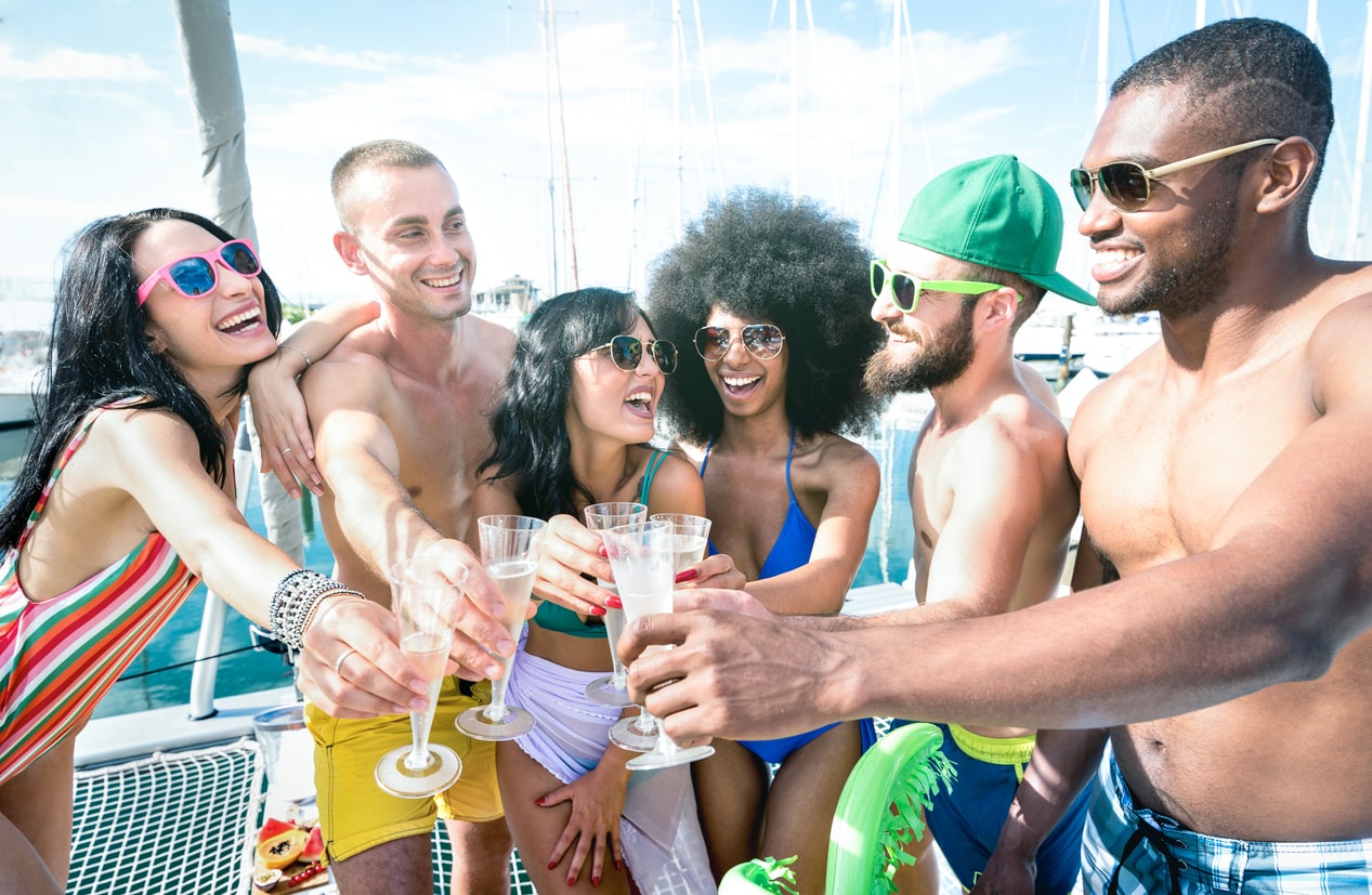 Group celebrating a birthday on board a yacht in Marbella, laughter and toasts under the sun